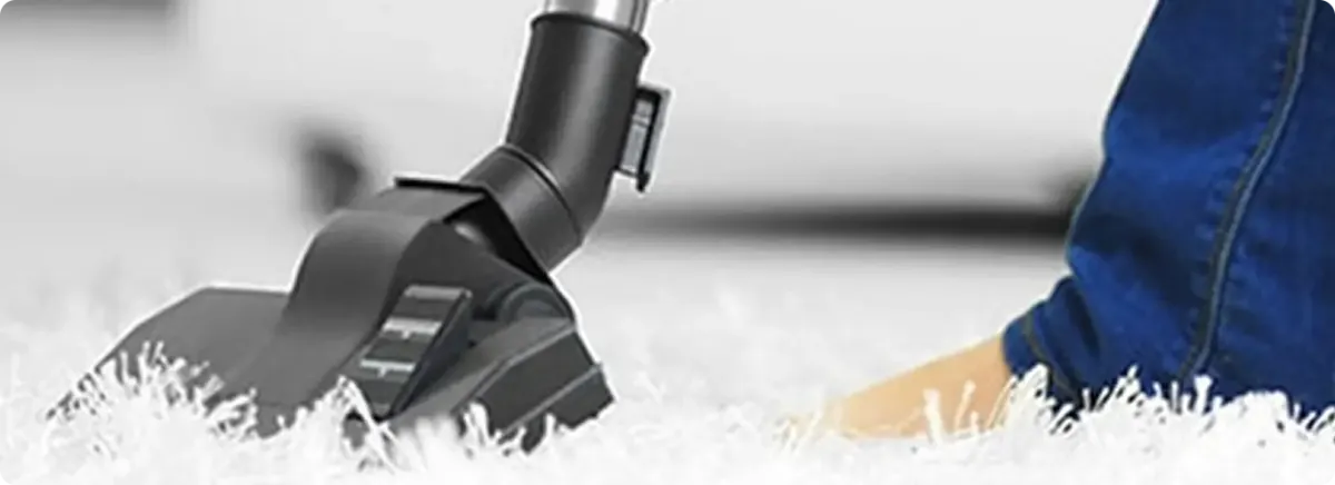Close-up of a professional vacuuming a white carpet in Hastings On Hudson.